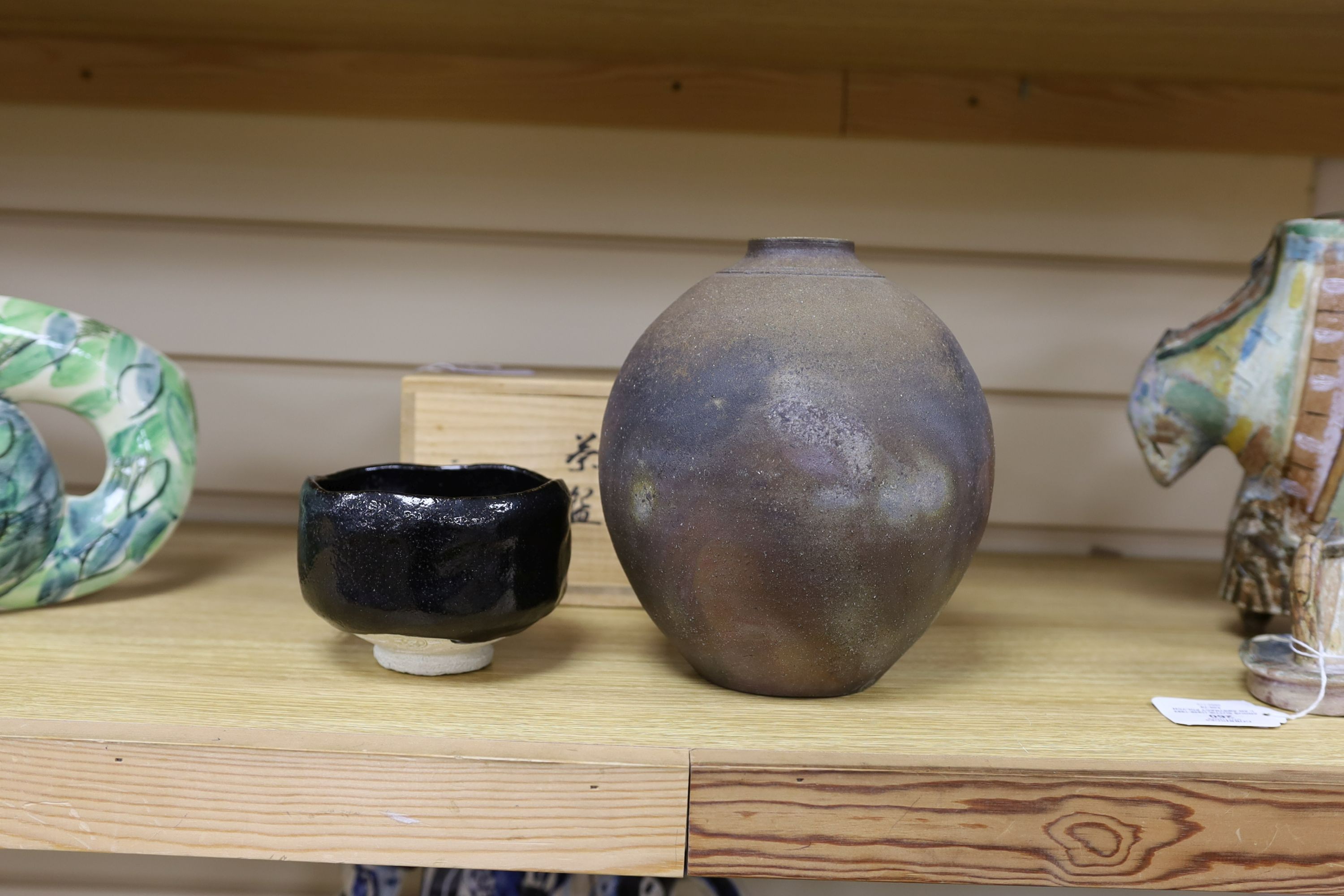 Japanese studio pottery: a boxed black glaze stoneware unomi tea bowl, with impressed mark, together with a ovoid vase, marked, 21cm tall